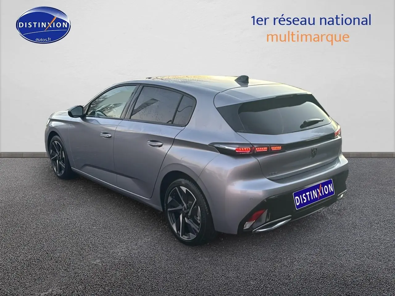 Peugeot 308 gris Artense vue 3/4 arrière droit, feux LED et jantes alliage visibles.
