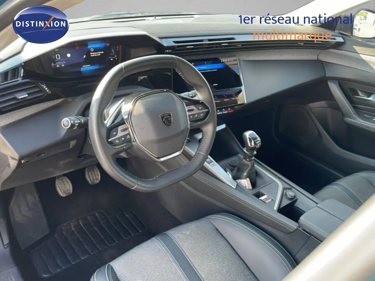 Vue intérieure côté conducteur de la Peugeot 308 1.2 PureTech 130ch Allure 2024, volant cuir et boîte manuelle.