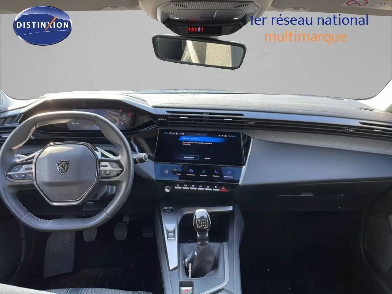 Vue intérieure avant du tableau de bord et volant de la Peugeot 308 bleu obsession avec boîte manuelle et écran tactile central.