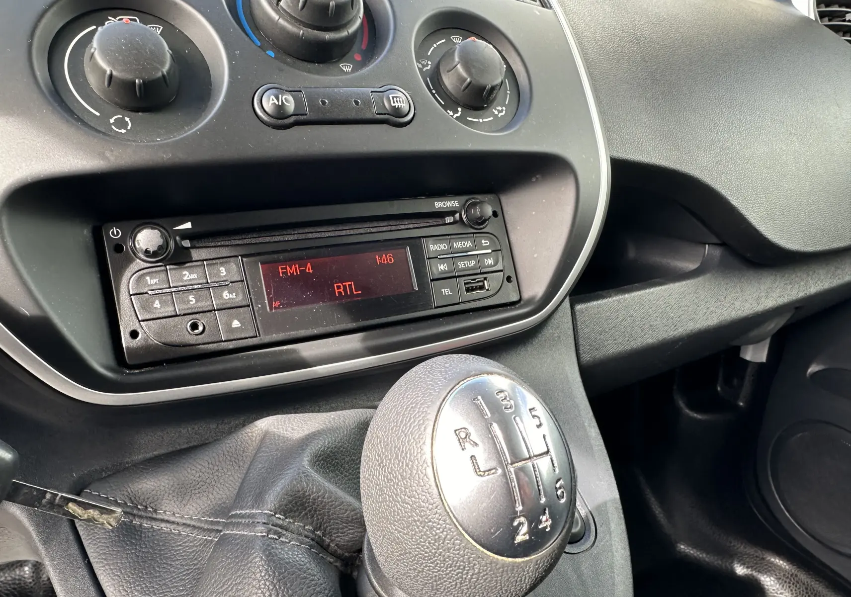 Gros plan sur la console centrale du Nissan NV250 blanc 2020, avec levier de vitesse manuel à 6 rapports et radio affichant RTL.