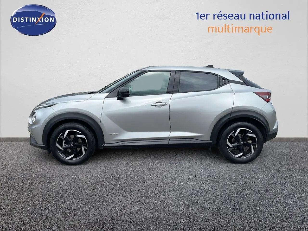 Profil côté gauche d'un Nissan Juke Hybrid 143ch Business+ gris perle métal avec jantes noires et détails modernes.