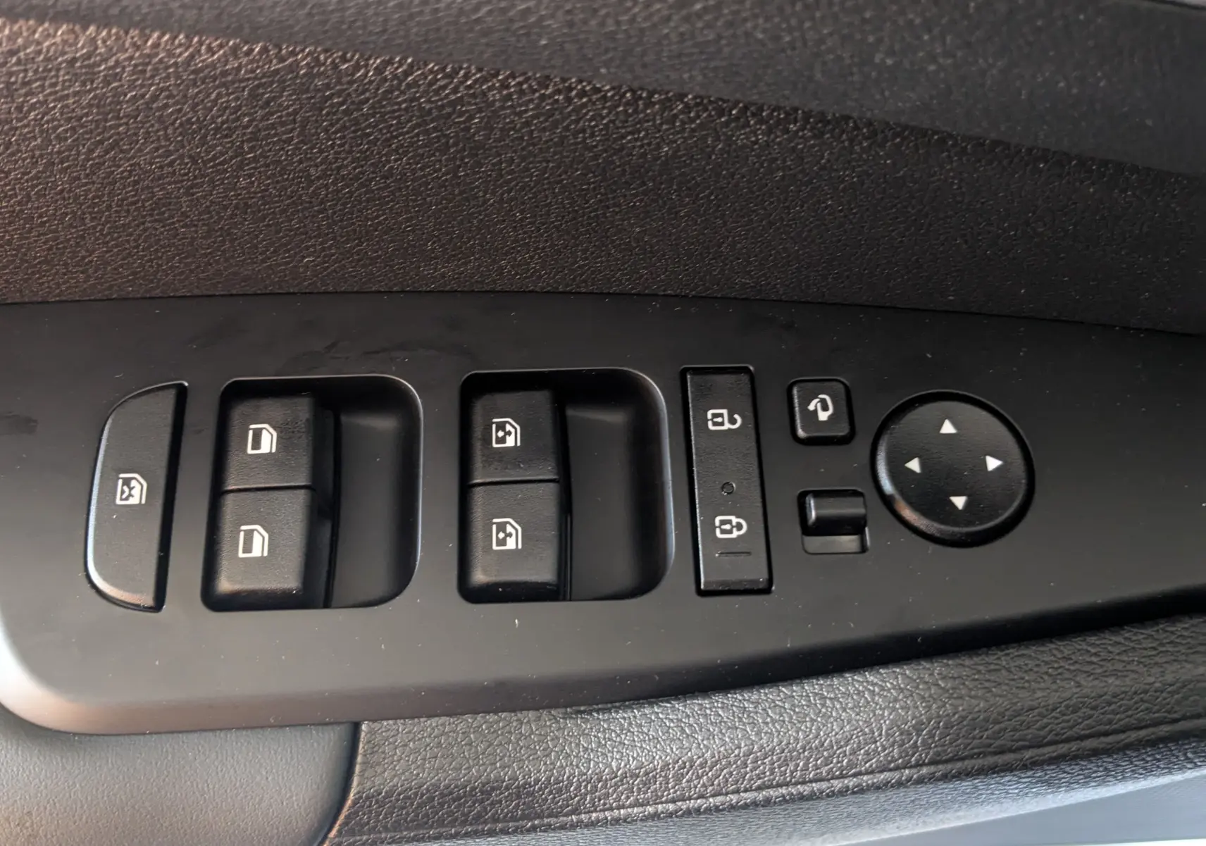 Panneau de commandes des vitres et rétroviseurs côté conducteur du Kia Sportage blanc MY25, finition Style.