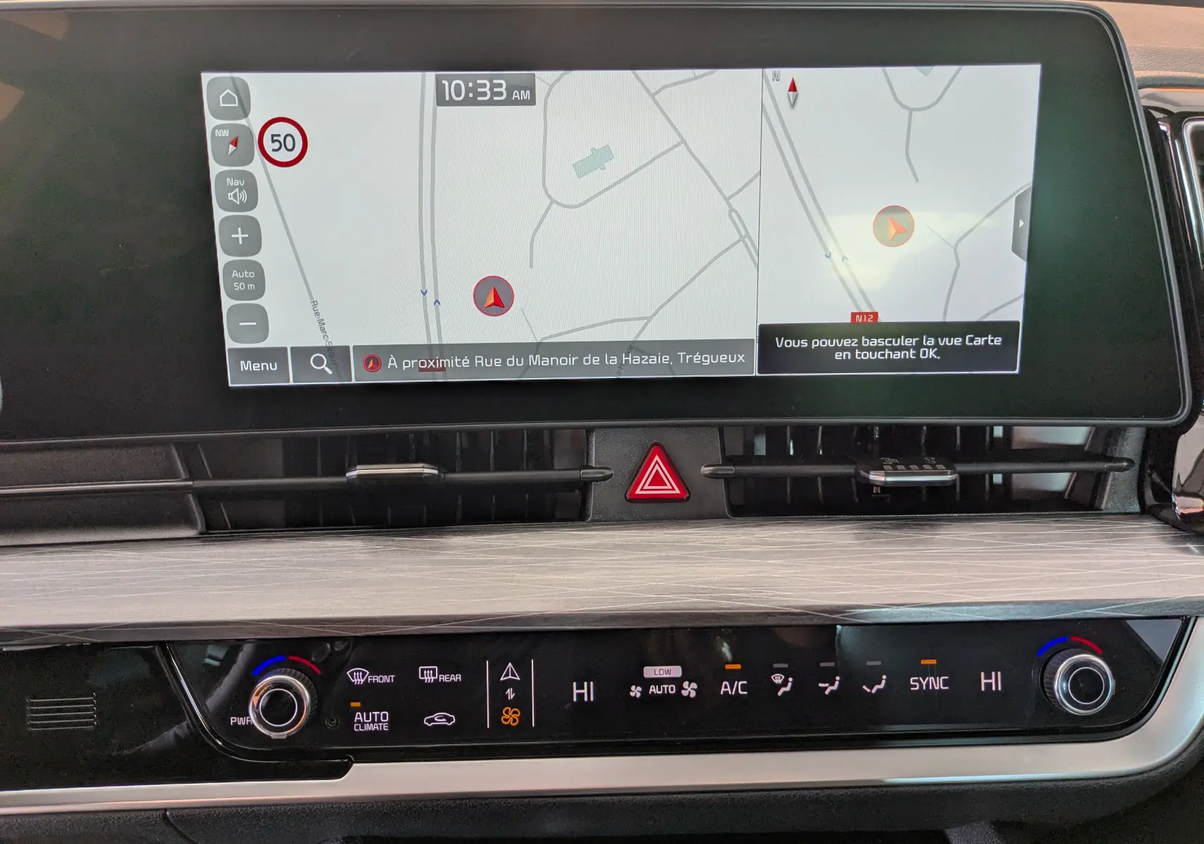 Écran tactile de navigation du Kia Sportage MY25 avec commandes de climatisation automatique bizone en plan rapproché.