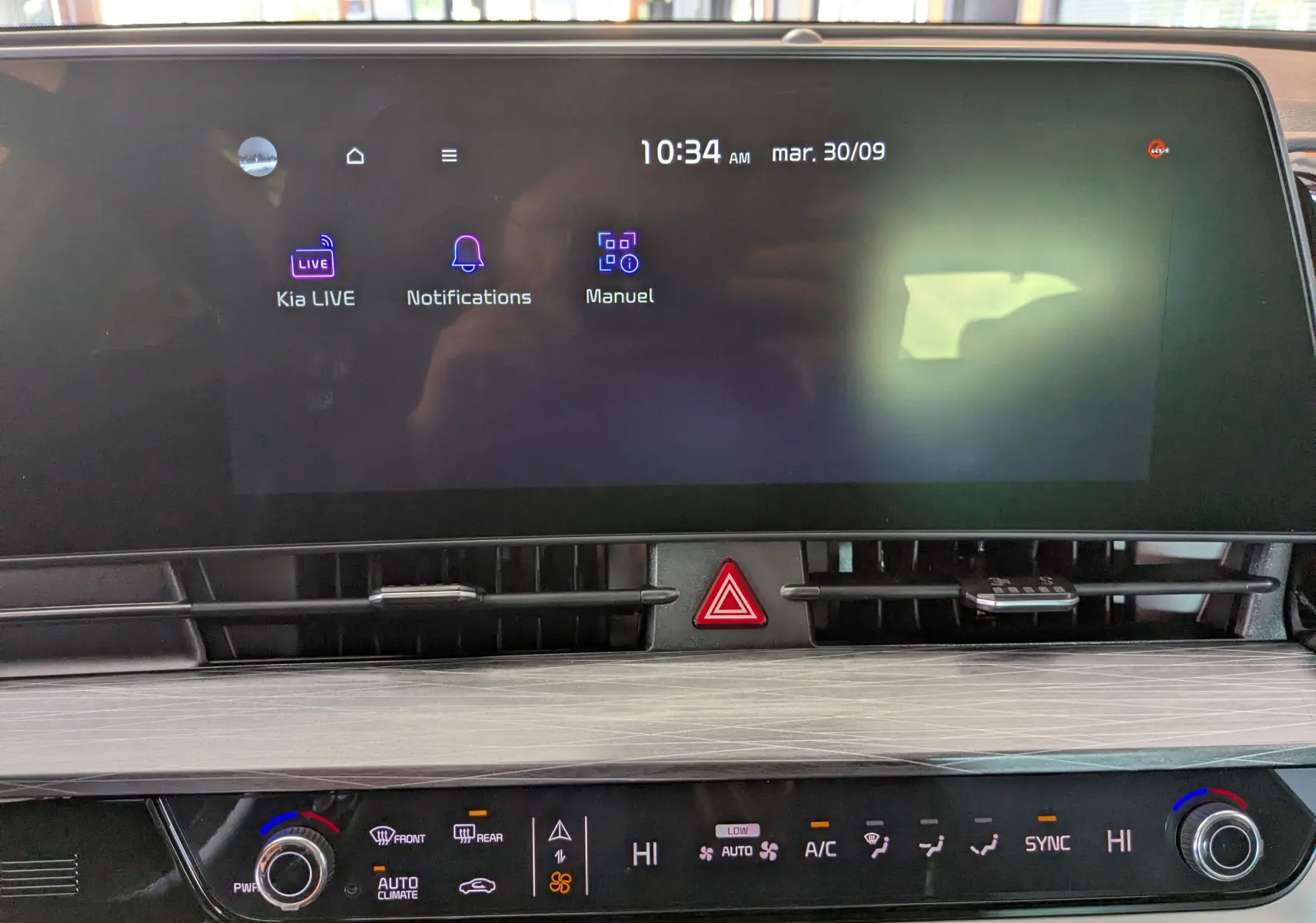 Écran tactile central du tableau de bord du Kia Sportage blanc MY25, affichant menu Kia LIVE et commandes climatisation.