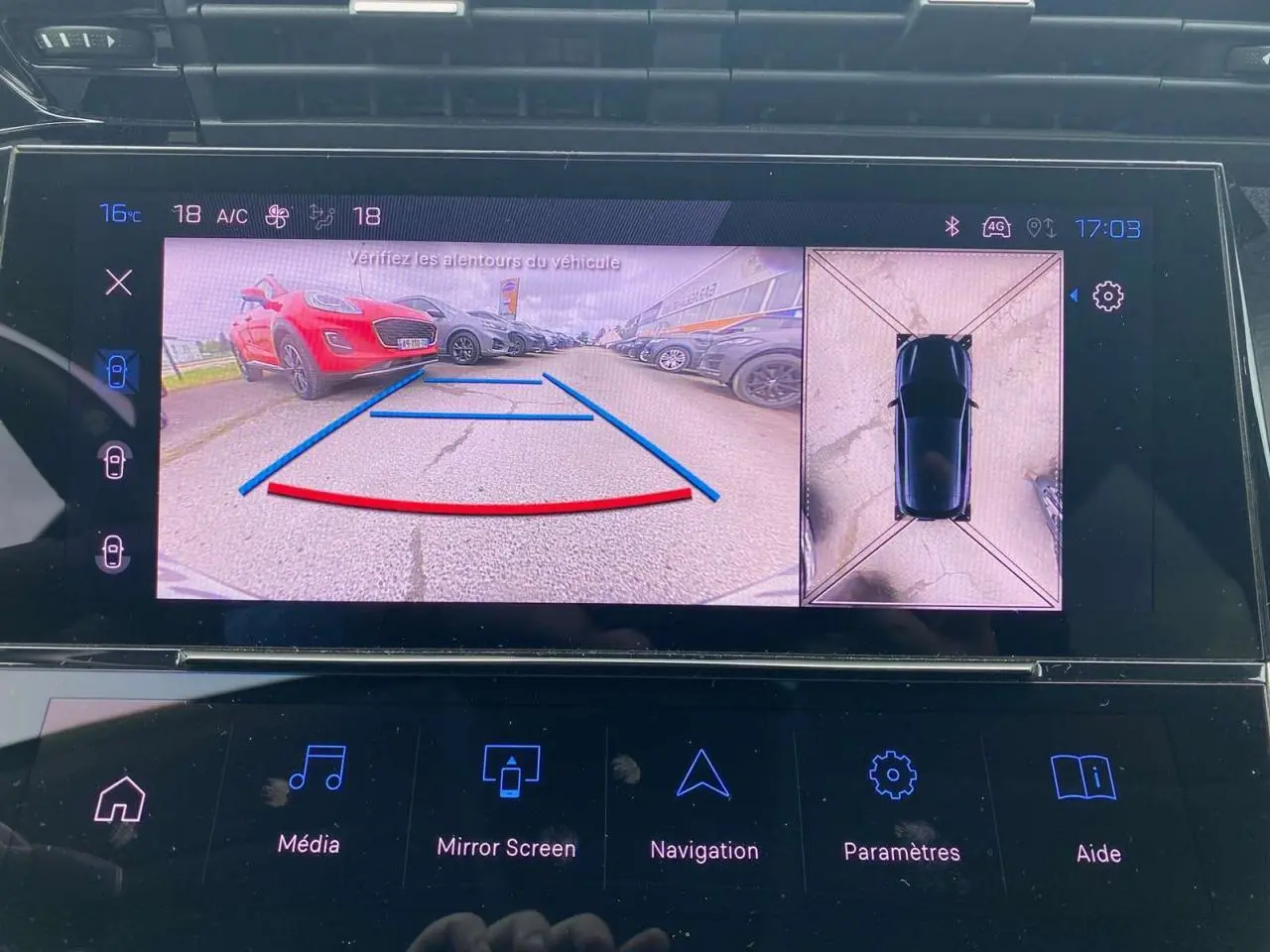 Affichage de la caméra 360° sur écran tactile, vue arrière et vue aérienne du véhicule noir en stationnement.