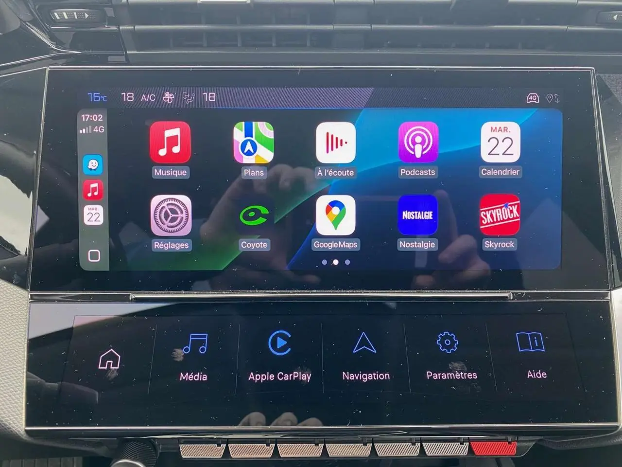 Écran tactile central de la Peugeot 308 2023 affichant Apple CarPlay et applications connectées.