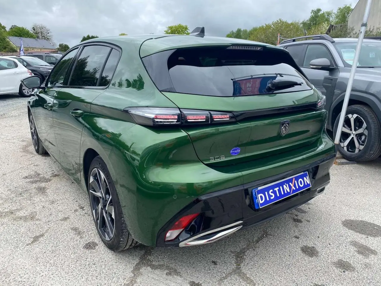 Vue 3/4 arrière droite d'une Peugeot 308 vert olivine avec feux LED et jantes alliage 17 pouces diamantées
