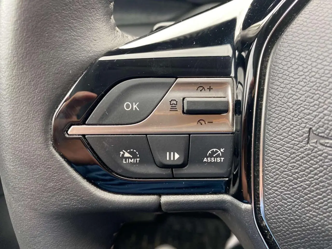Gros plan sur les commandes de régulation de vitesse au volant de la Peugeot 308 2023 finition Allure Pack.