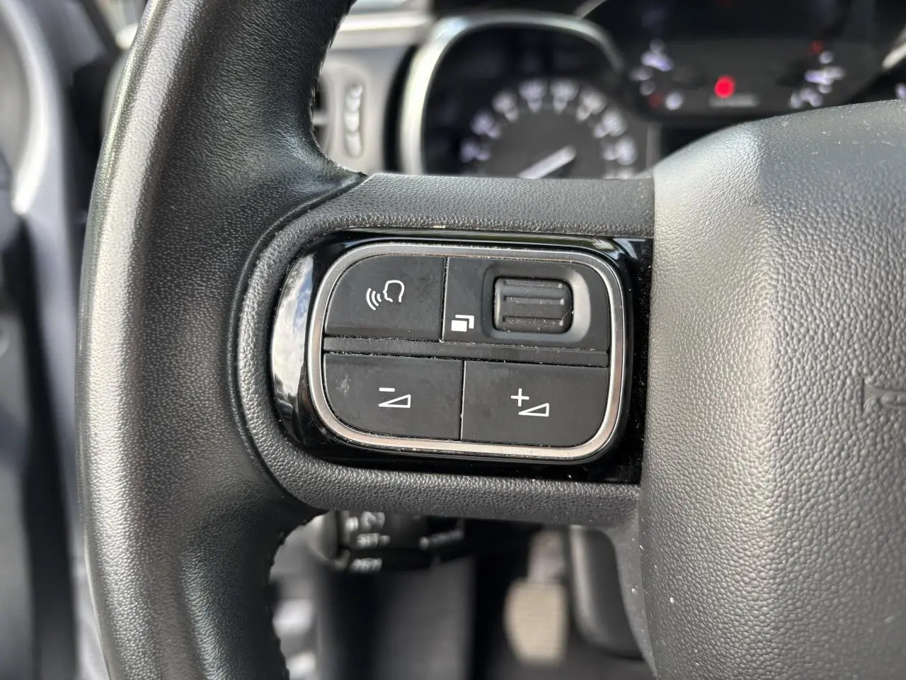 Gros plan sur les commandes audio au volant de la Citroën C3 2019, finition Feel Business, en intérieur noir.