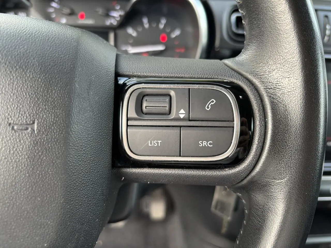 Gros plan sur les commandes audio et téléphone au volant noir de la Citroën C3 2019.