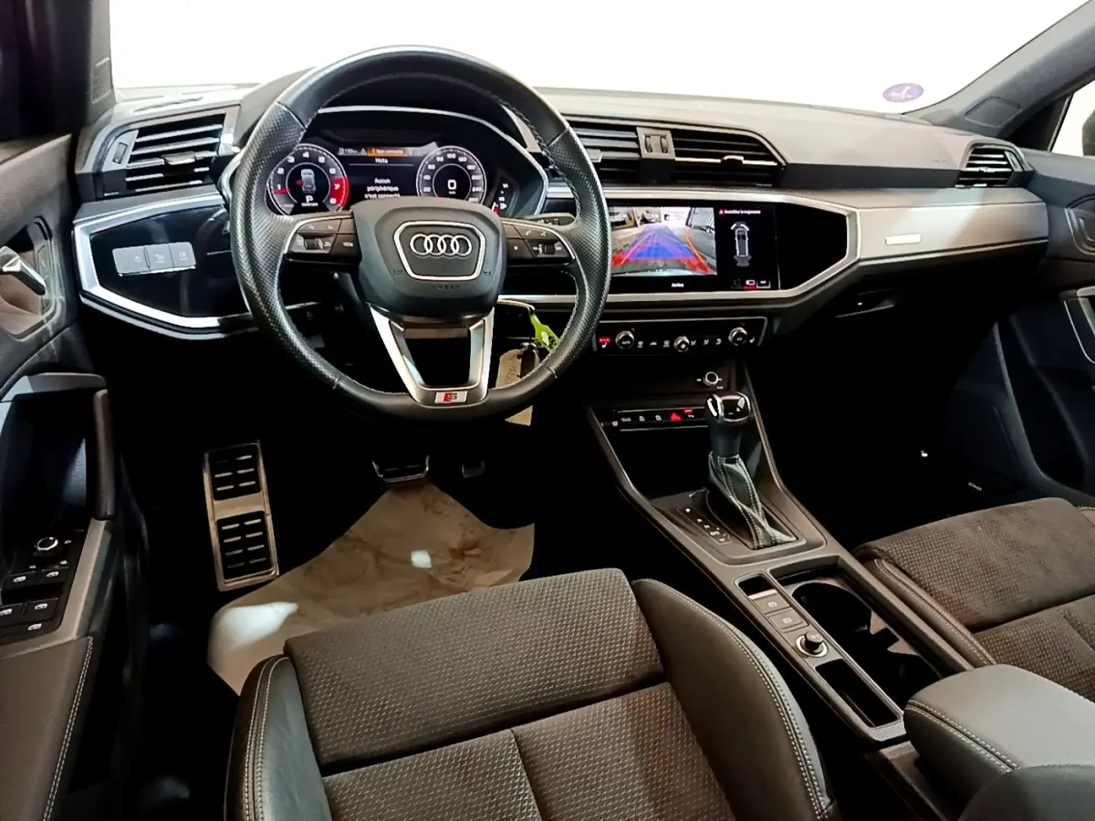 Intérieur Audi Q3 35 TFSI S Line 2022, vue avant centrée sur volant cuir et tableau de bord digital avec écran tactile.