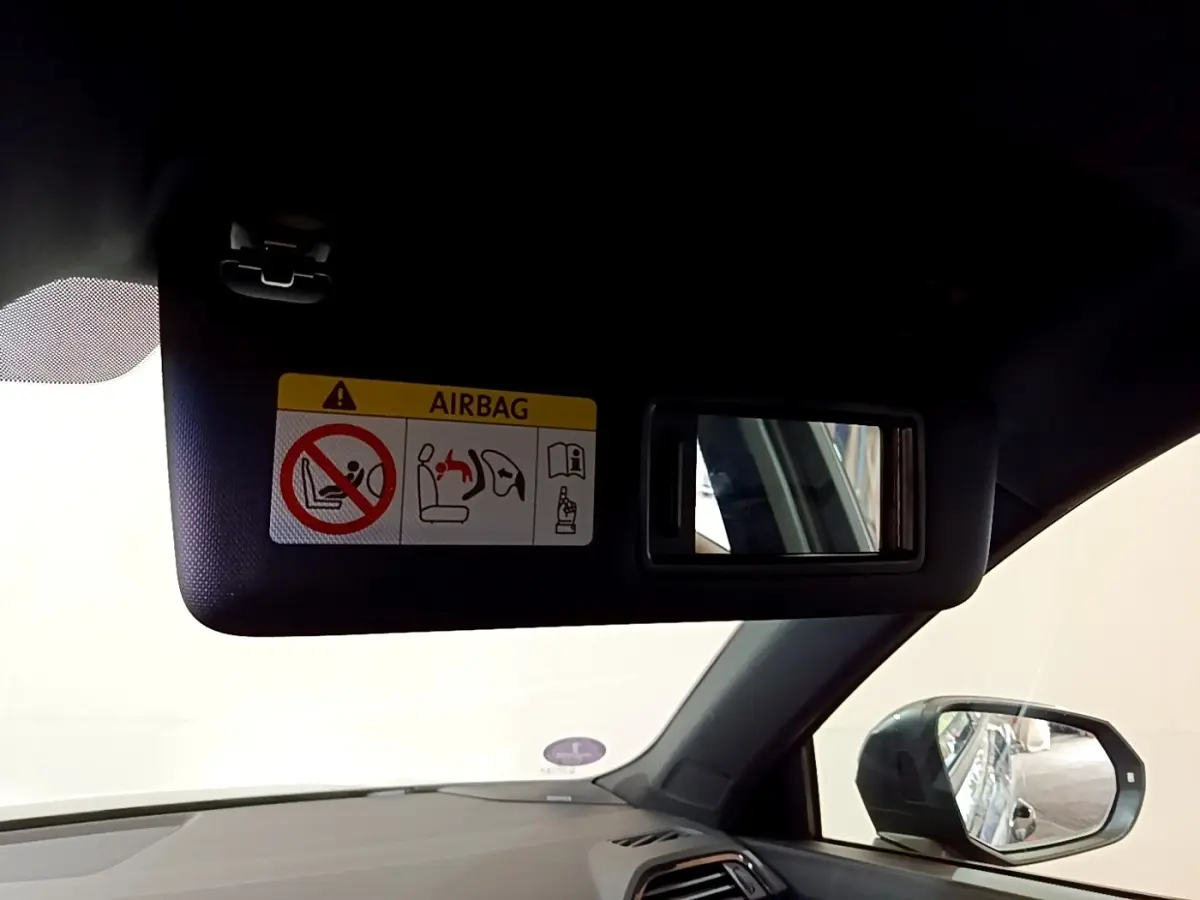 Détail du pare-soleil côté conducteur avec miroir intégré et avertissement airbag dans l’Audi Q3 gris foncé 2022.