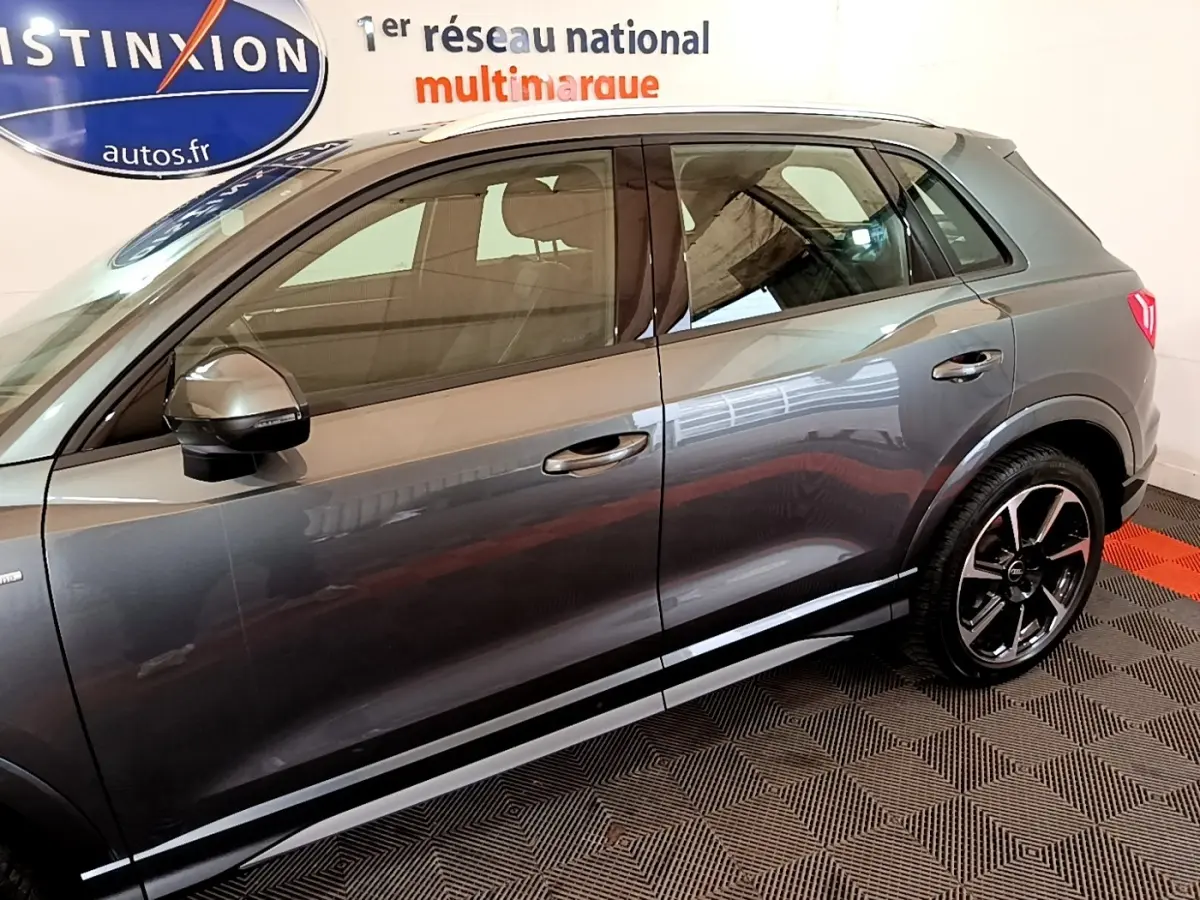 Vue latérale droite d'un Audi Q3 gris foncé 35 TFSI S Line avec jantes noires et détails chromés.