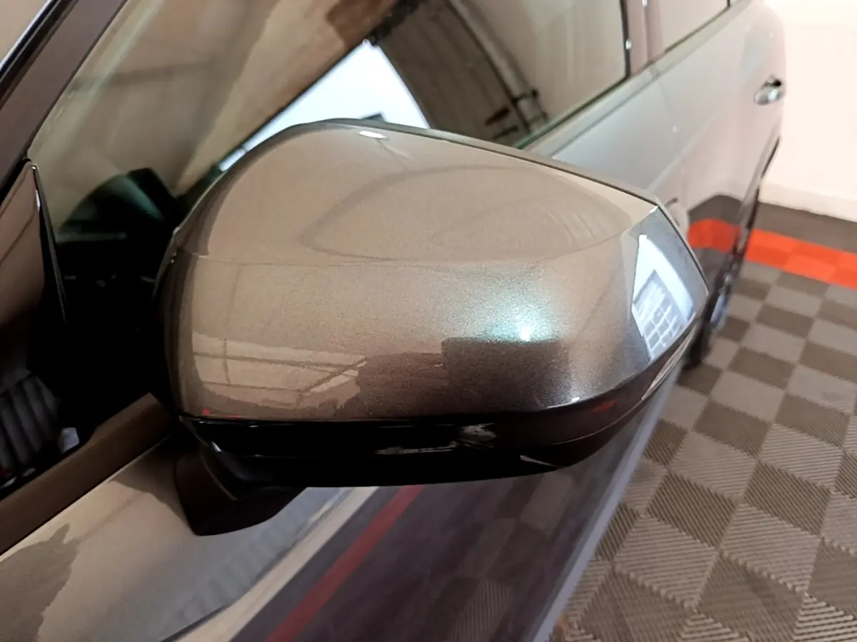 Rétroviseur côté gauche gris foncé d'un Audi Q3 35 TFSI S Line 2022, avec carrosserie partiellement visible en intérieur.