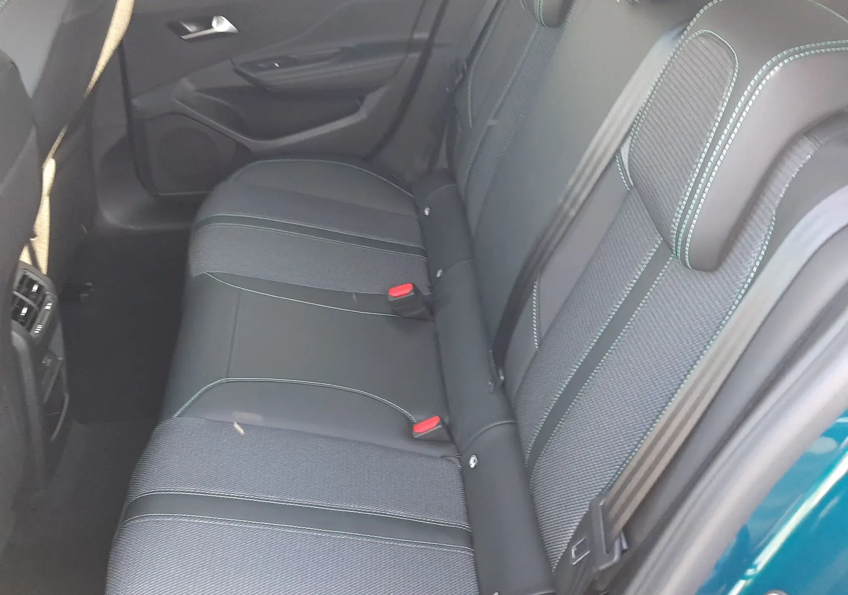 Vue intérieure côté conducteur de la Peugeot 308 2026 bleu obsession, sièges en cuir et tissu avec surpiqûres contrastées.