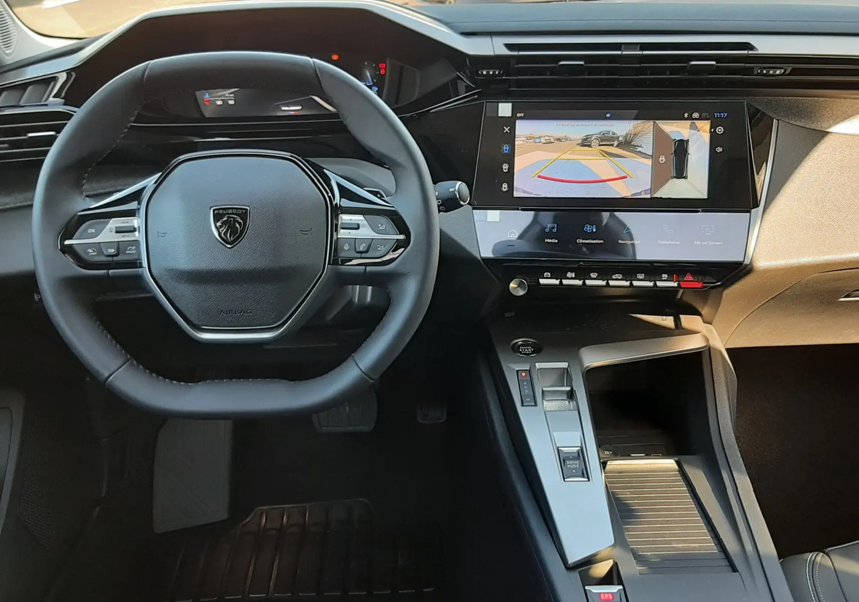 Vue intérieure côté conducteur du Peugeot 308 Bleu Obsession 2026, mettant en valeur les sièges en cuir et tissu avec surpiqûres contrastées.