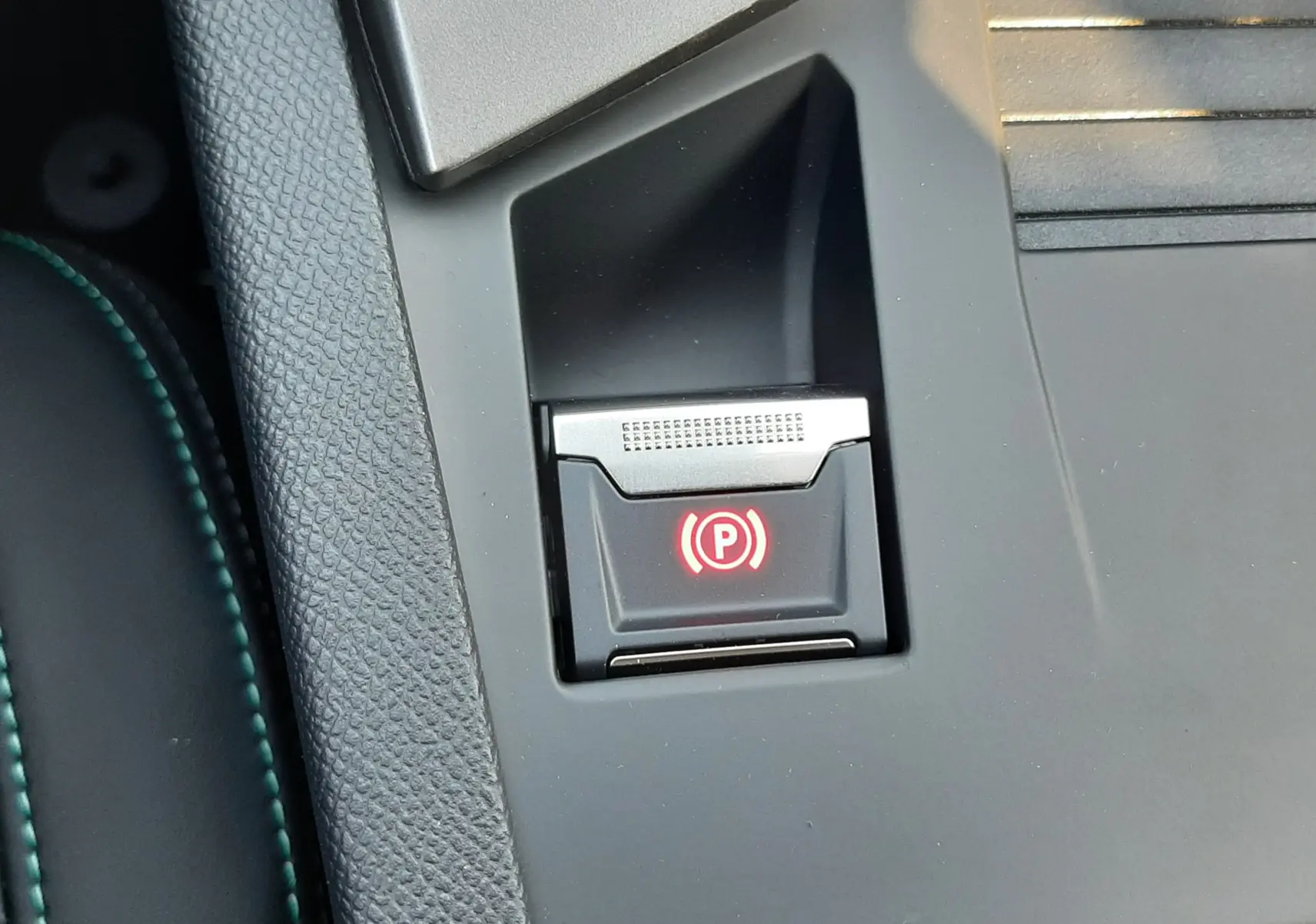 Gros plan sur le bouton Drive Mode noir intégré dans la console centrale grise du Peugeot 308 Bleu Obsession 2026.