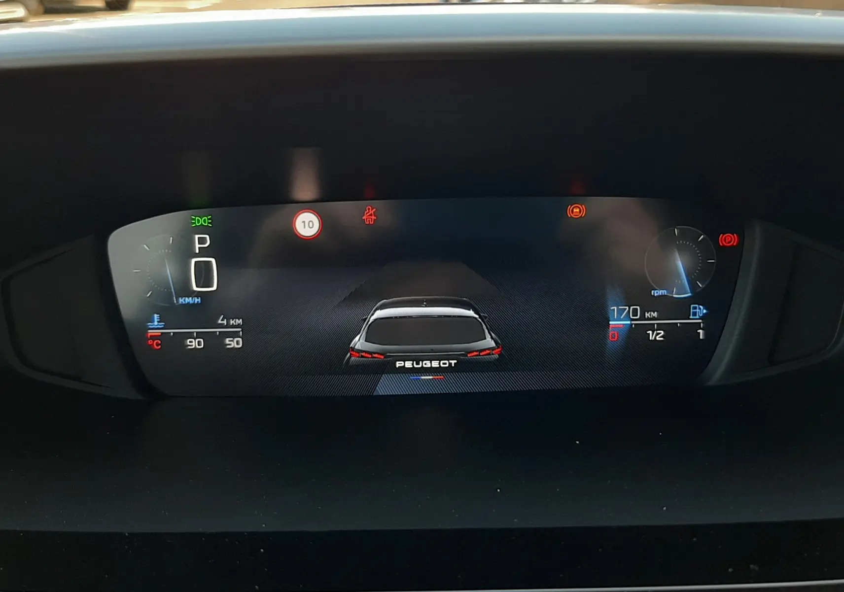 Tableau de bord numérique de Peugeot 308 2026, affichage vitesse, régime moteur et autonomie, vue de face intérieure.