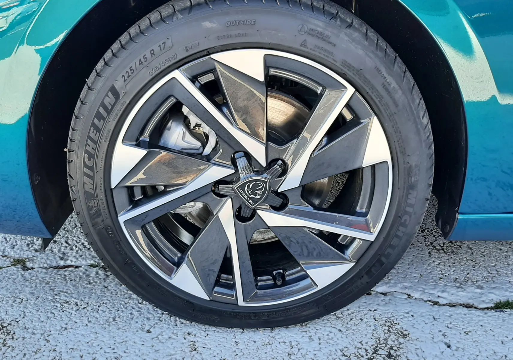 Gros plan sur l'avant droit bleu obsession du Peugeot 308 2026, mettant en valeur le phare et la calandre distinctive.