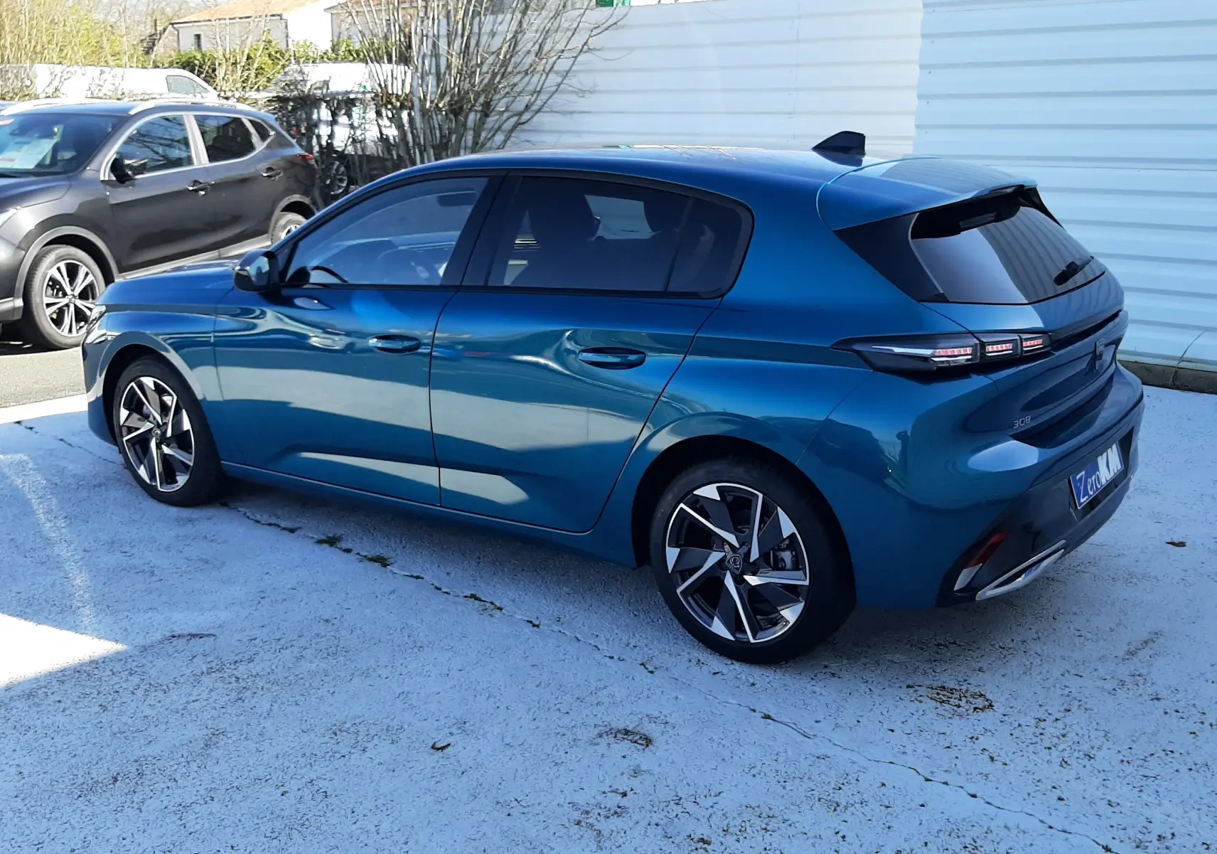 Gros plan sur la roue avant droite d'une Peugeot 308 Bleu Obsession avec jante alliage bicolore et pneu Michelin.