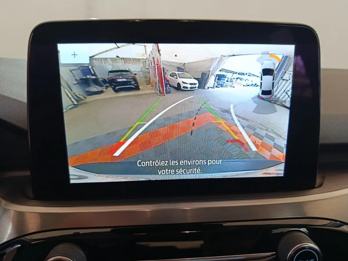 Écran tactile intérieur montrant la caméra de recul avec guidage et vue 3D du Ford Kuga gris foncé.