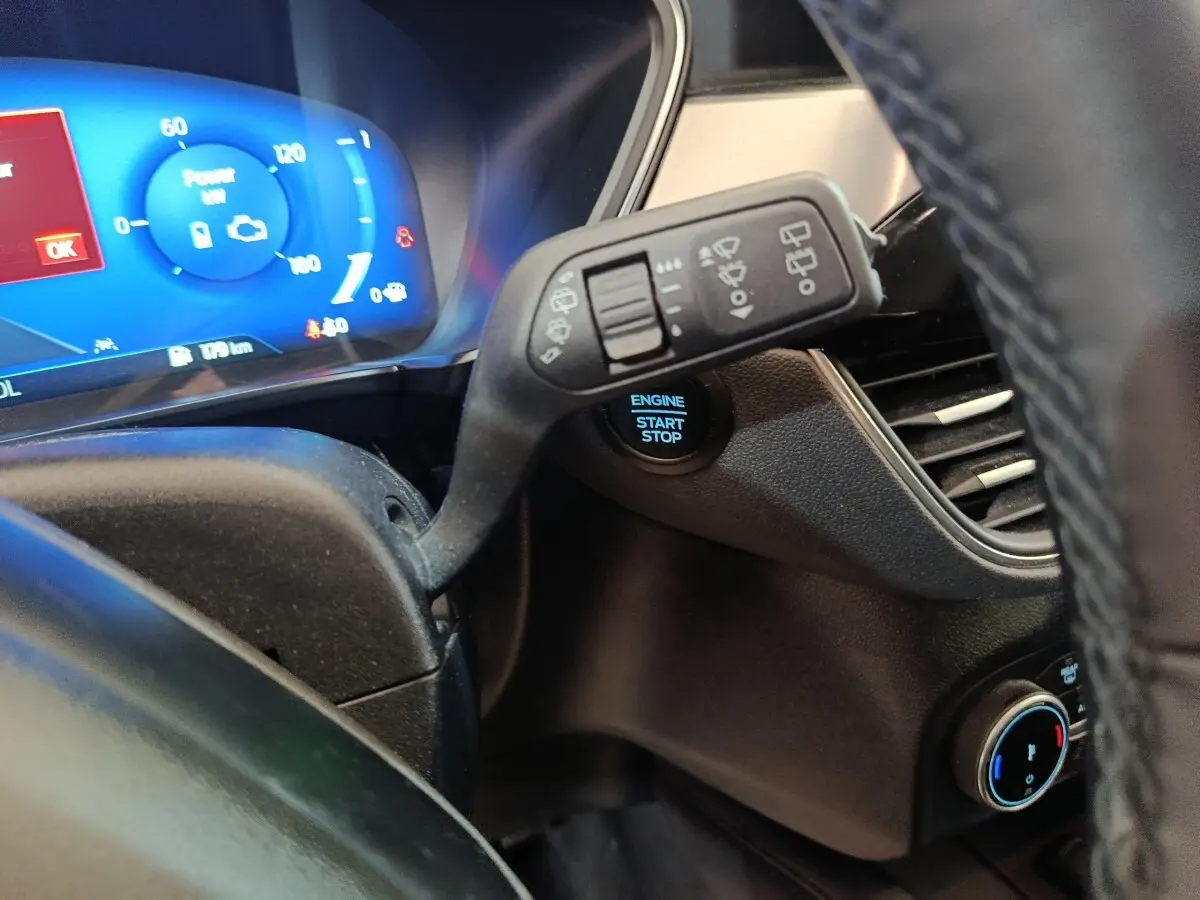 Gros plan intérieur sur le combiné d'instruments bleu et la commande des essuie-glaces du Ford Kuga 2023.