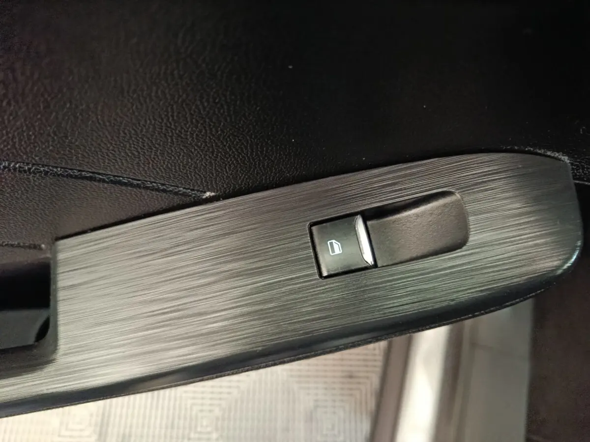 Gros plan sur l'interrupteur de lève-vitre côté conducteur du Ford Kuga gris foncé 2023, finition Titanium.