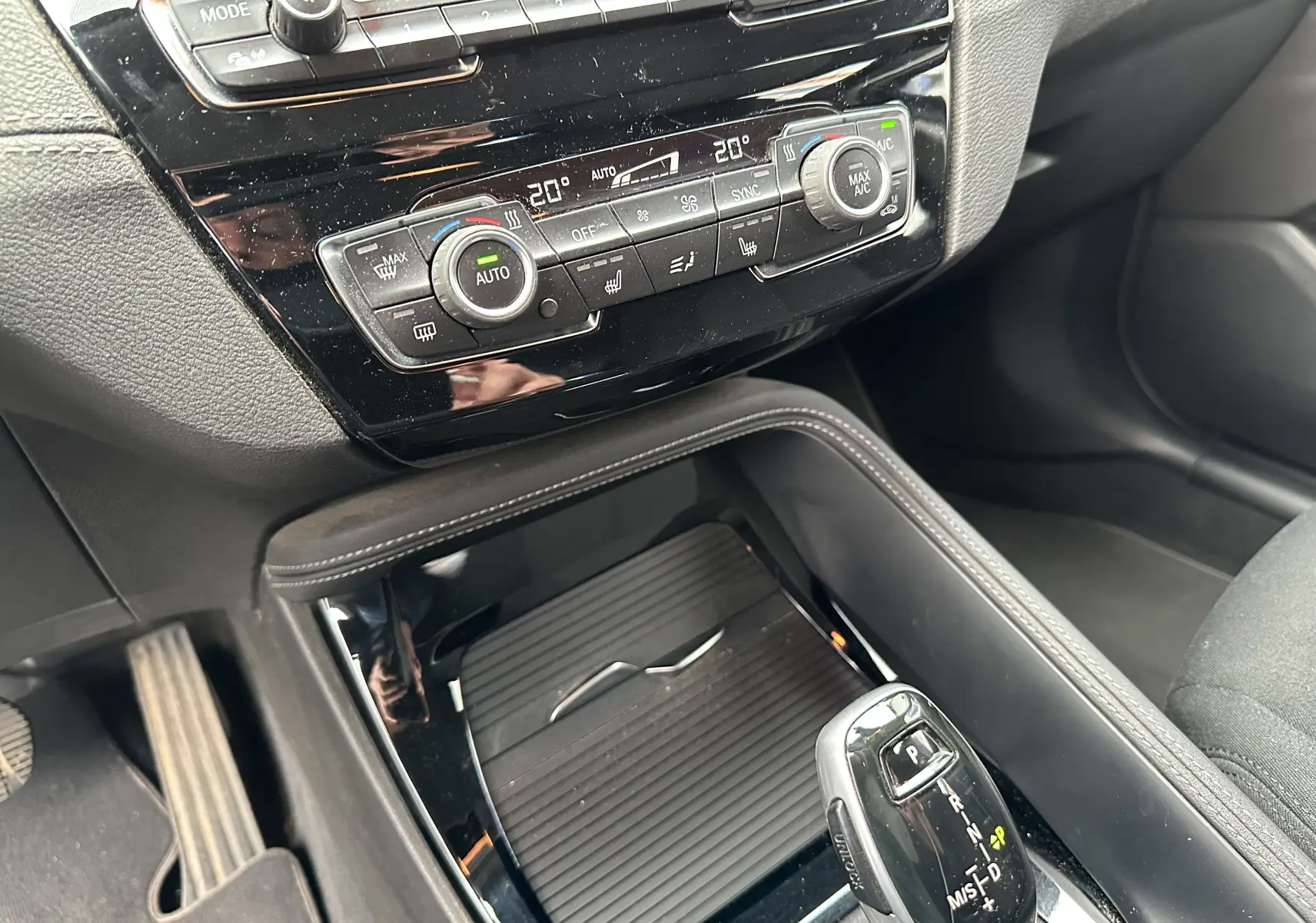 Gros plan sur la console centrale du BMW X2 gris 2018, montrant la climatisation automatique et le levier de vitesse automatique.