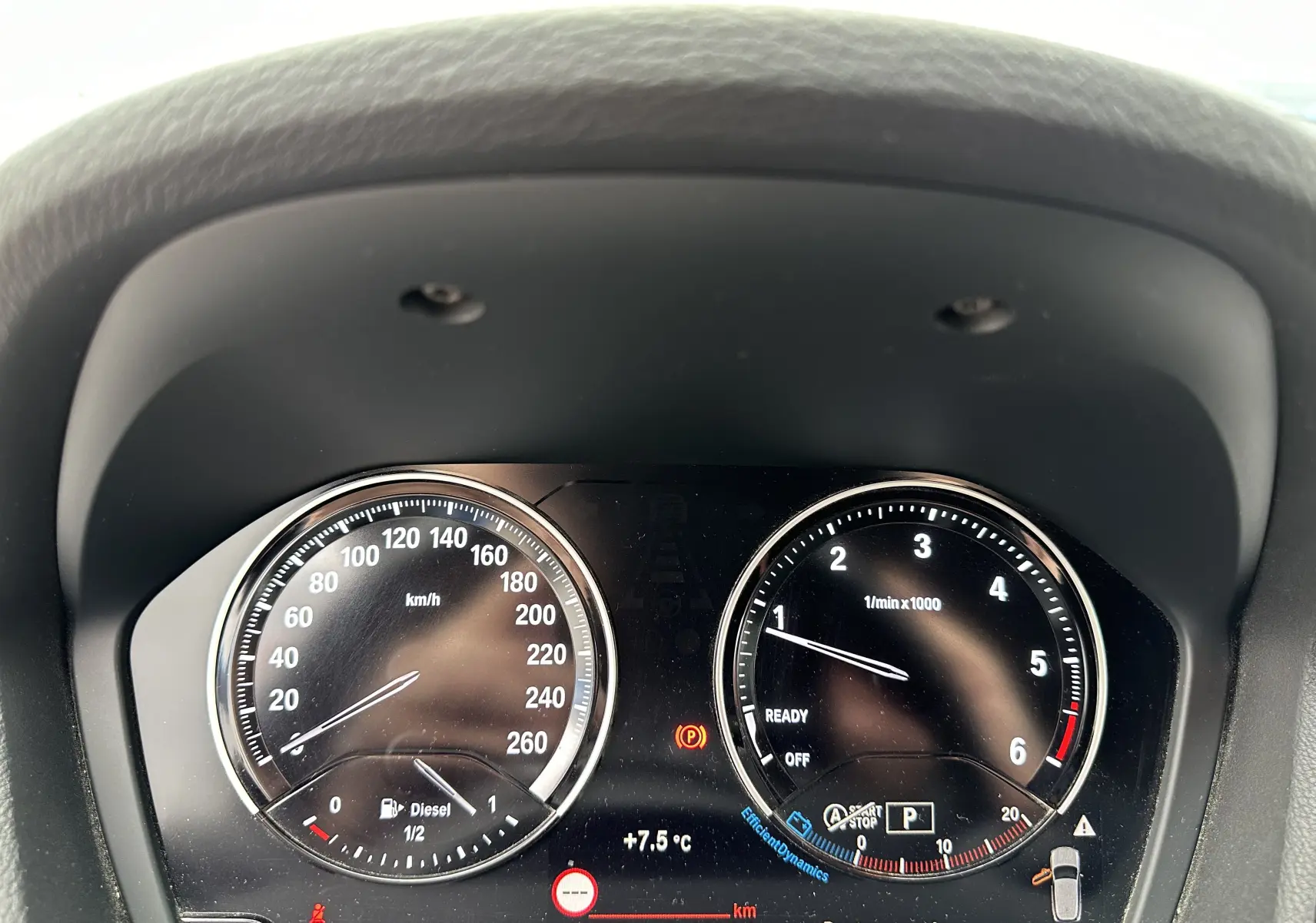 Tableau de bord du BMW X2 gris 2018 montrant la vitesse, le compte-tours et un avertissement de porte ouverte.