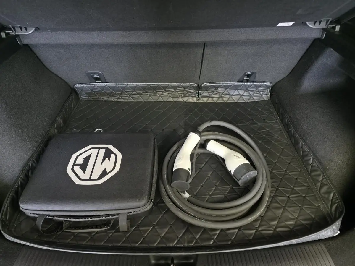 Coffre ouvert du MG4 électrique 2022 avec tapis matelassé noir, câble de recharge et sac de rangement MG.