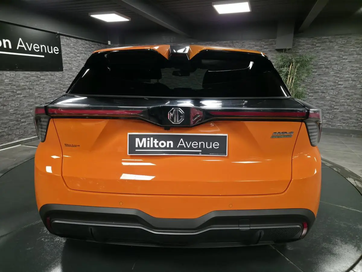 Vue arrière du MG4 électrique orange avec toit noir et bandeau lumineux LED intégrée au hayon.