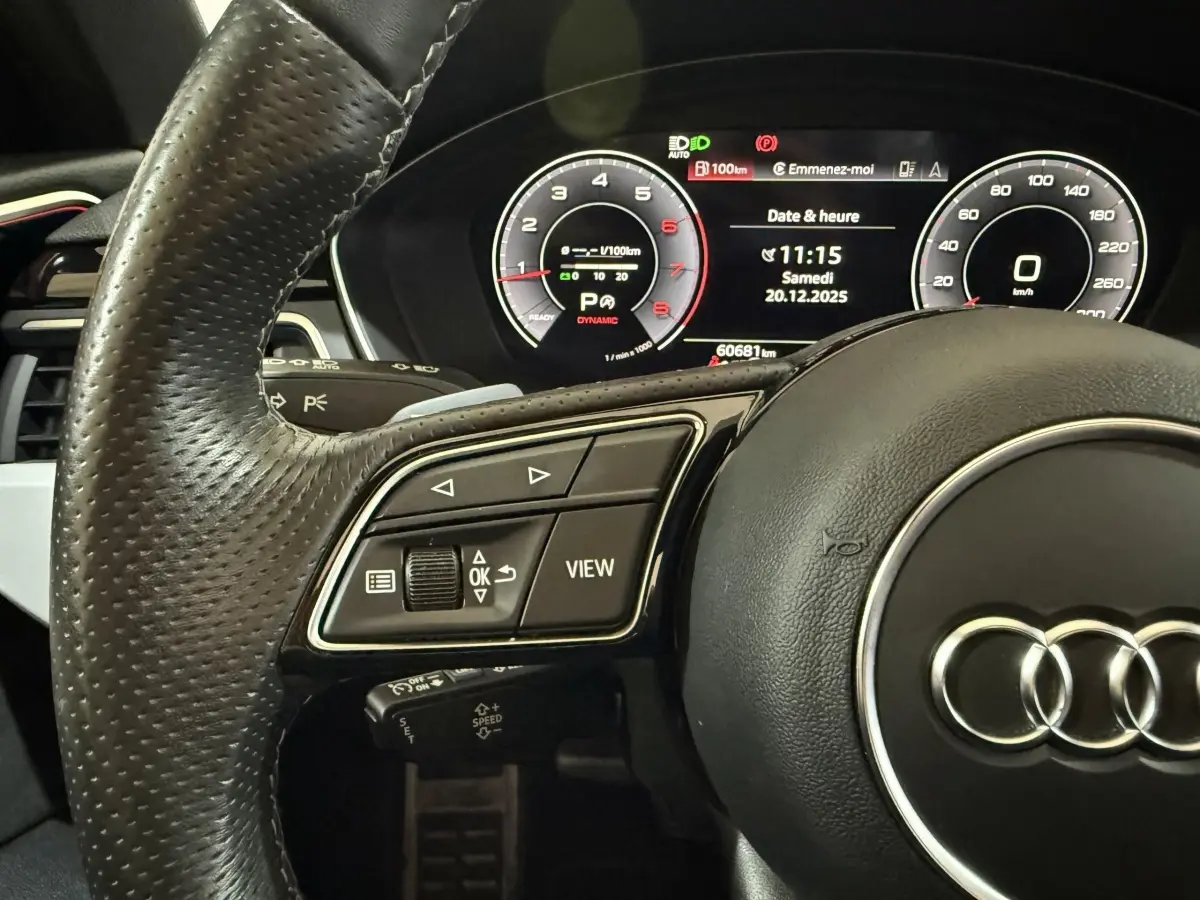 Gros plan sur le volant cuir noir d'une Audi A4 35 TFSI 2022 avec tableau de bord numérique affichant la vitesse et l'heure.