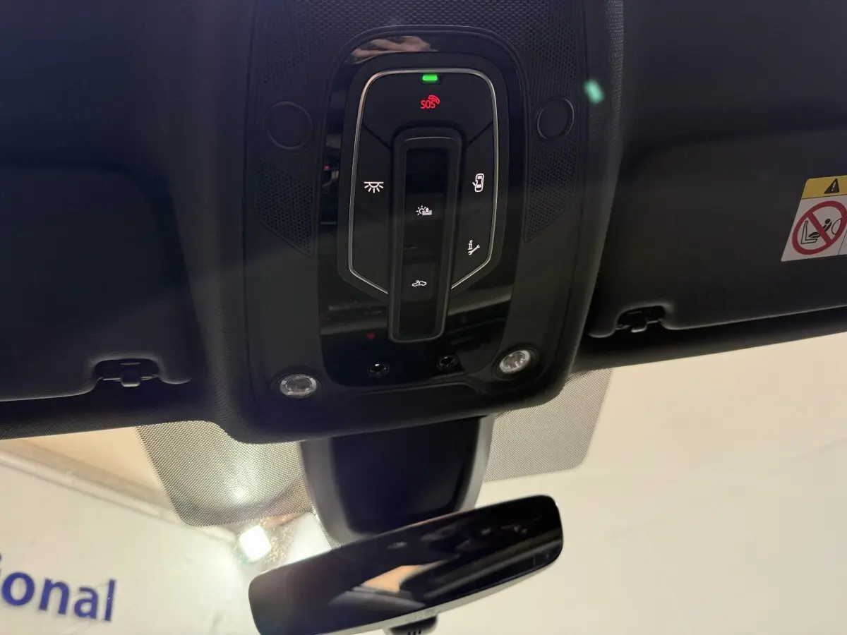 Vue intérieure du plafonnier noir avec commandes lumineuses et bouton SOS de l'Audi A4 gris foncé 2022.