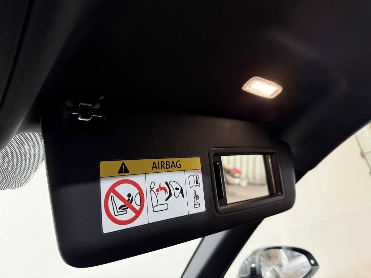 Détail du pare-soleil côté conducteur d’une Audi A4 gris foncé 35 TFSI 2022 avec miroir et avertissement airbag.