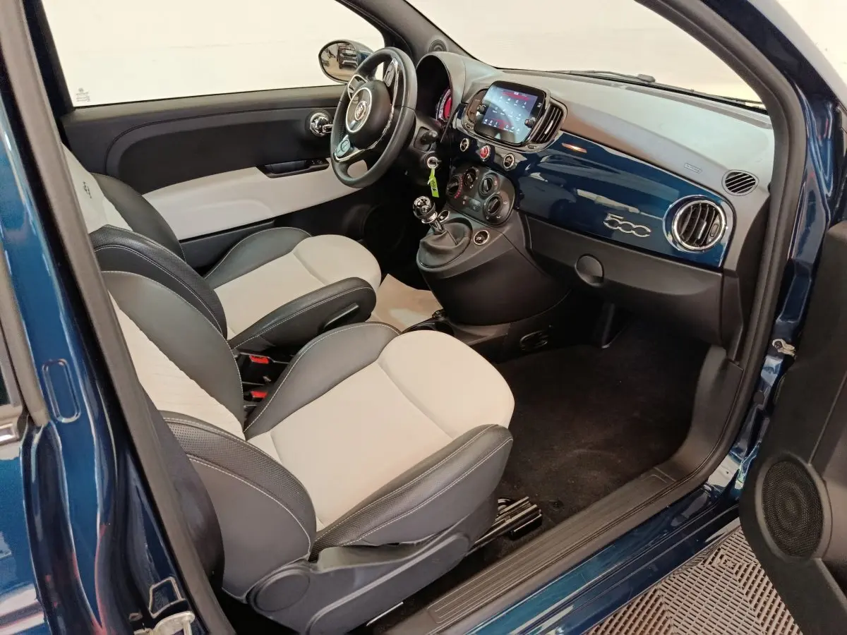 Vue intérieure côté conducteur de la FIAT 500 Hybrid bleu, avec sièges bicolores et tableau de bord brillant 500.