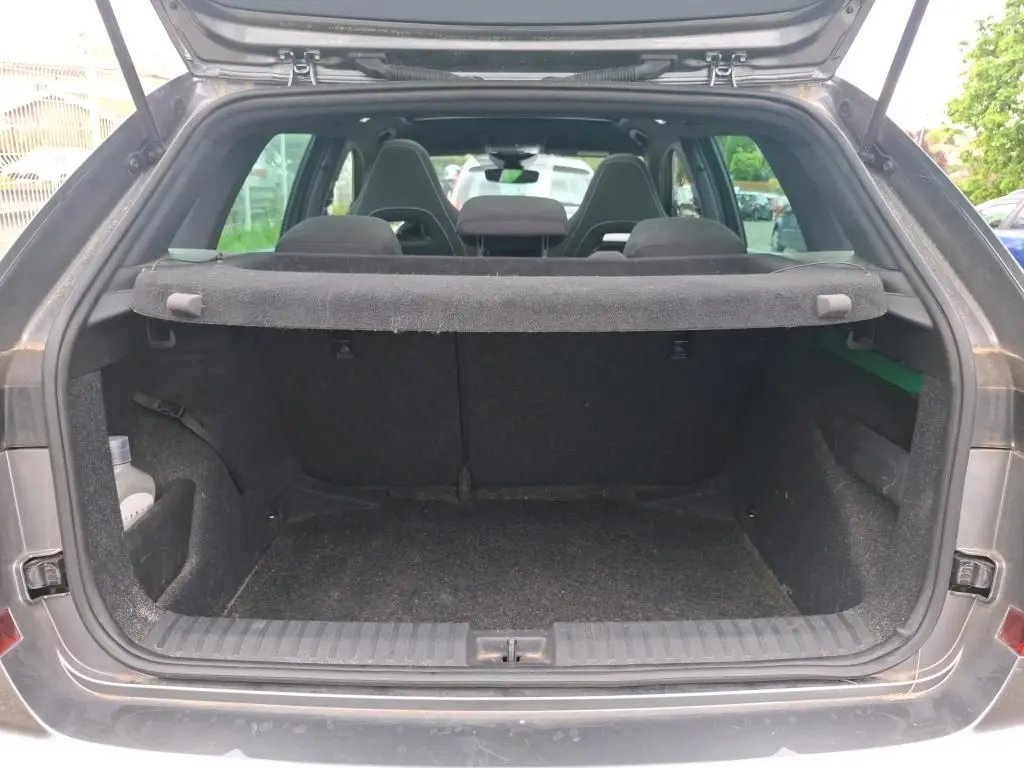 Coffre ouvert vu de l'arrière d'un Skoda Kamiq gris foncé 2024, montrant l'espace de chargement et la plage arrière.