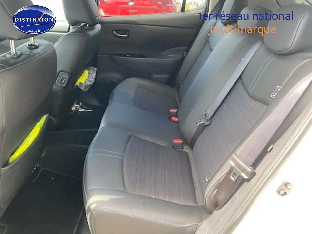 Vue intérieure sur les sièges arrière en tissu et cuir d'une Nissan Leaf électrique blanc nacré, côté droit ouvert.