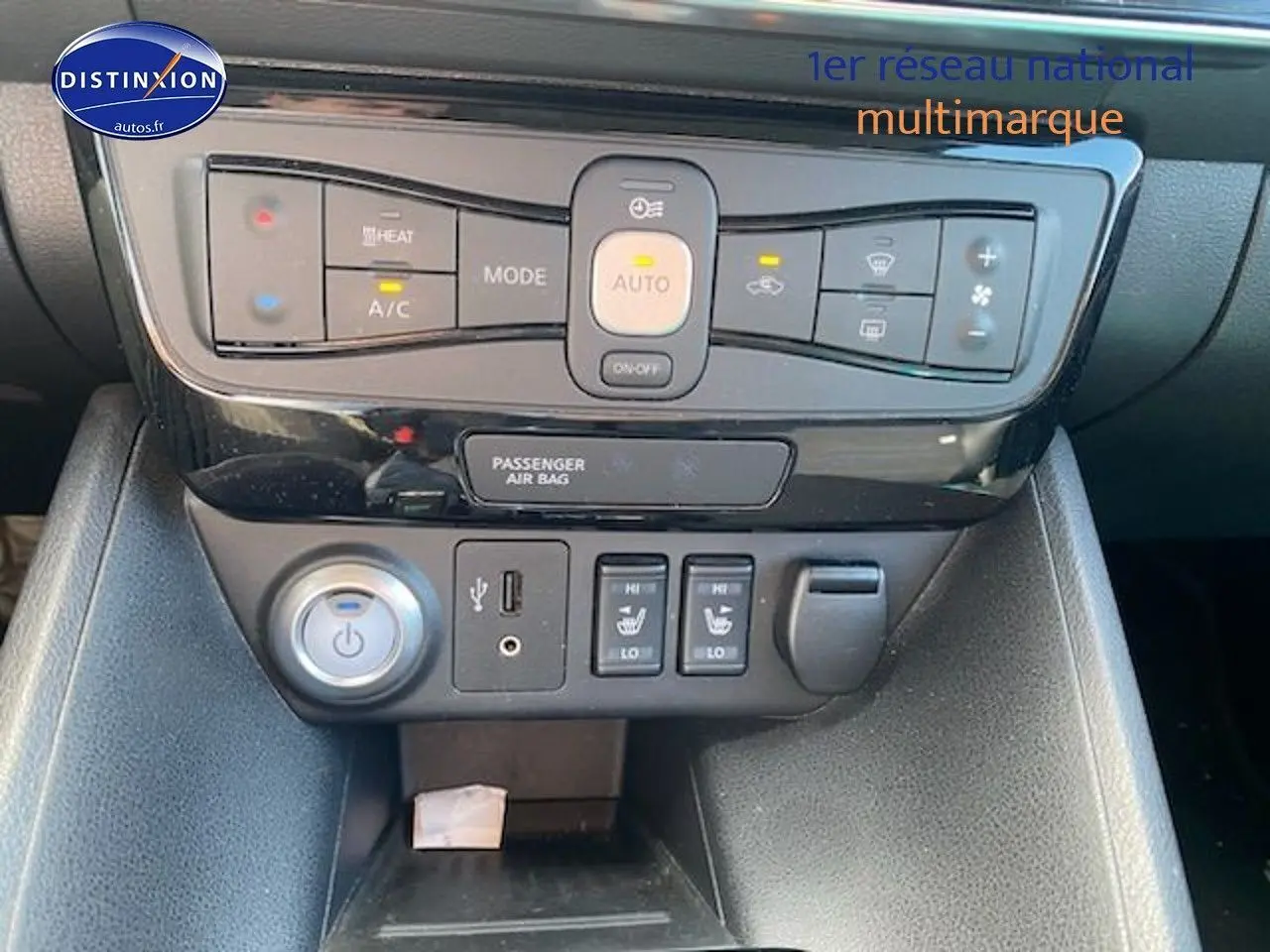 Console centrale avec commandes de climatisation et sièges chauffants dans une Nissan Leaf électrique blanc nacré de 2019