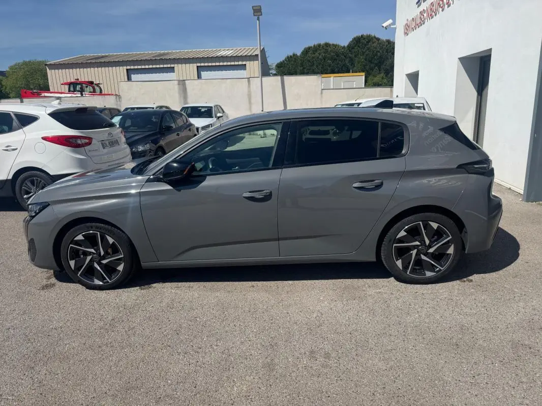 Peugeot 308 Hybrid gris vue de profil côté gauche, avec jantes alliage 17 pouces et vitres teintées.