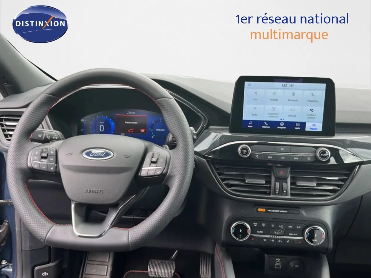 Vue intérieure du tableau de bord du Ford Kuga 2024 bleu chrome, avec volant multifonction et écran tactile central.