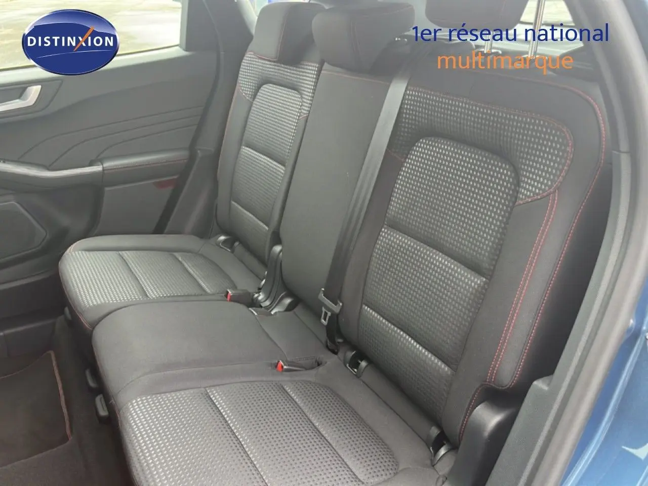 Vue intérieure côté droit des sièges arrière noirs avec surpiqûres rouges du Ford Kuga 2024 bleu chrome métal.
