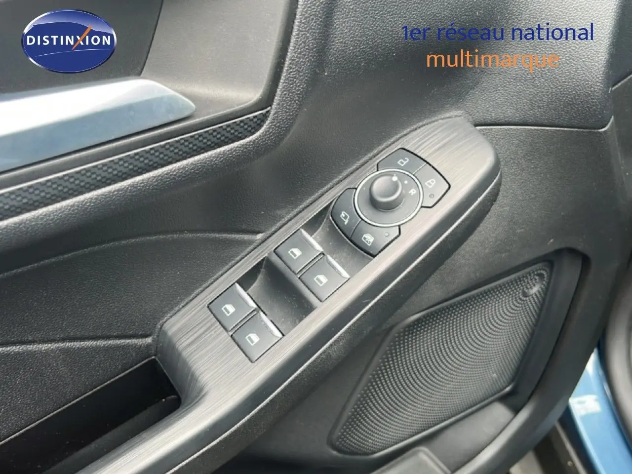 Détail des commandes de lève-vitres et rétroviseurs sur la porte côté gauche du Ford Kuga bleu chrome 2024.