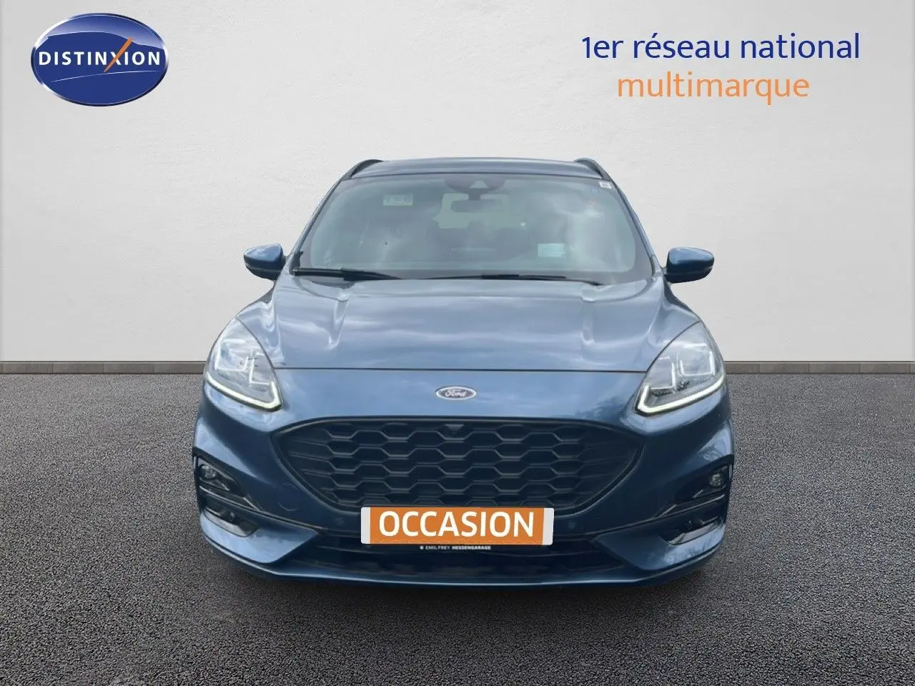 Vue frontale d'un Ford Kuga 2.0D EcoBlue 120ch ST-Line bleu chrome métal avec calandre noire et phares LED allumés.