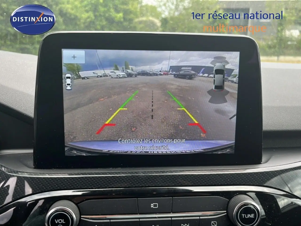 Écran central affichant la caméra de recul du Ford Kuga bleu chrome, vue intérieure sur le tableau de bord.