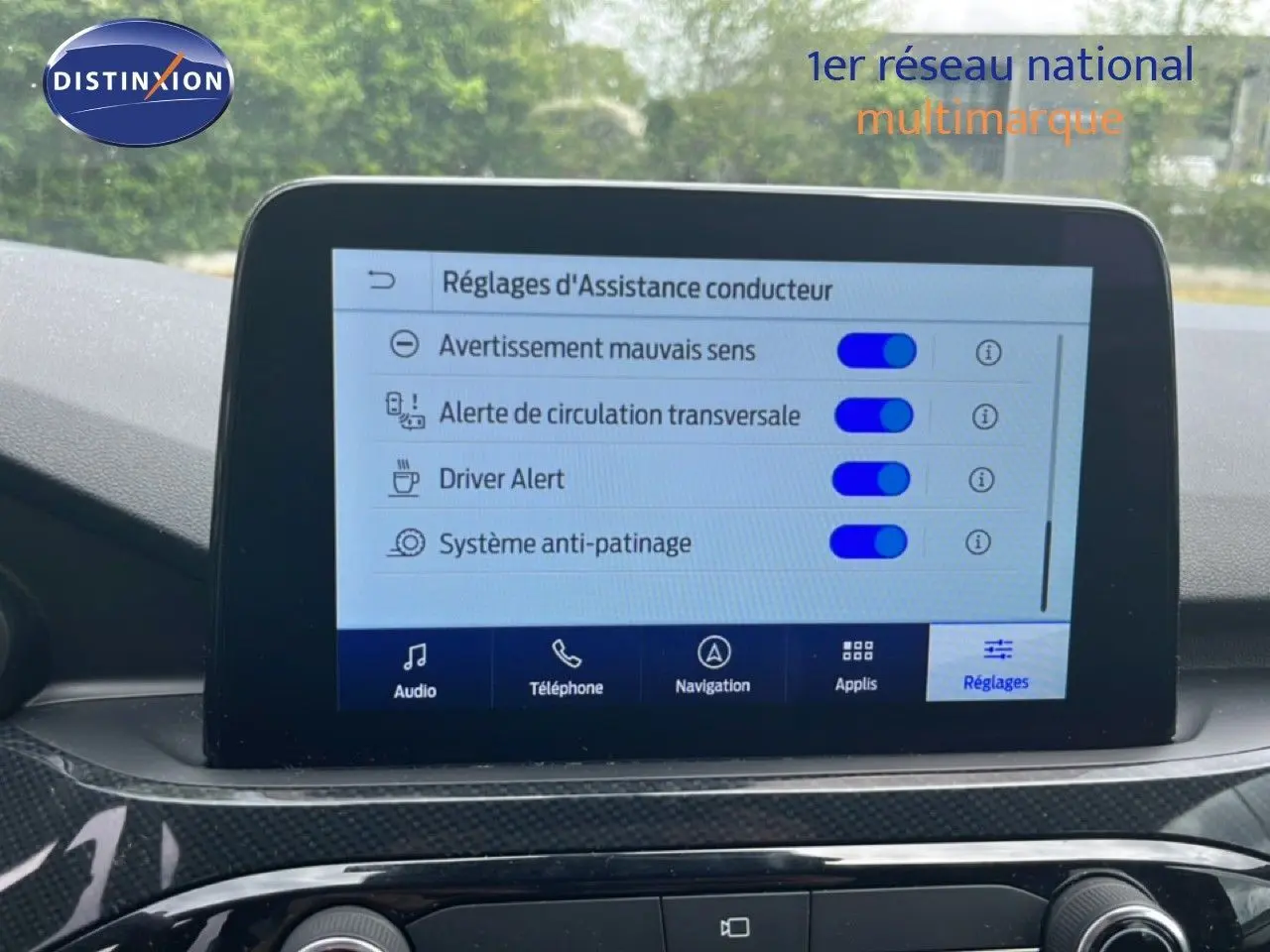 Écran tactile central affichant les réglages d’assistance conducteur dans un Ford Kuga 2024 bleu chrome, intérieur noir.