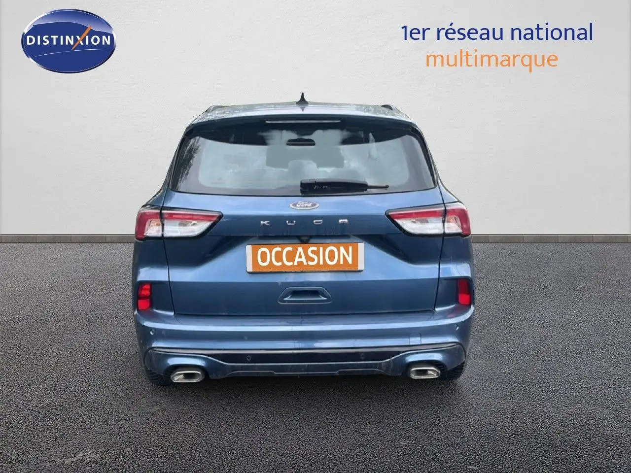 Vue arrière d'un Ford Kuga bleu chrome métal 2024 avec double sortie d'échappement et plaque "OCCASION".