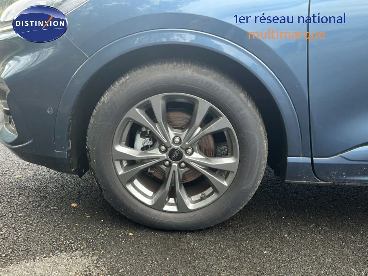Gros plan sur la roue avant gauche du Ford Kuga bleu chrome métal, mettant en valeur la jante alliage 18 pouces.