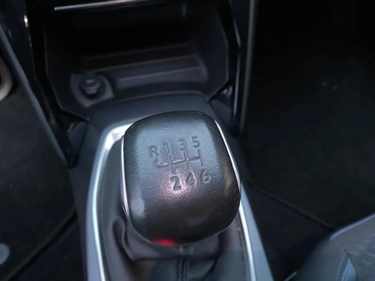 Le levier de vitesses manuel noir de la Peugeot 2008 2020, vue rapprochée de la console centrale.