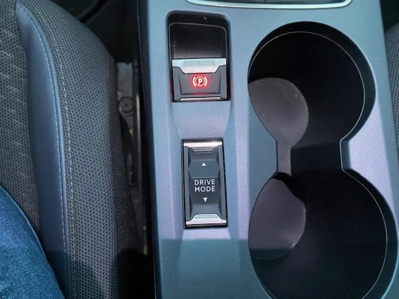 Gros plan sur la console centrale du Peugeot 2008 blanc, montrant le bouton Drive Mode et frein à main électronique.