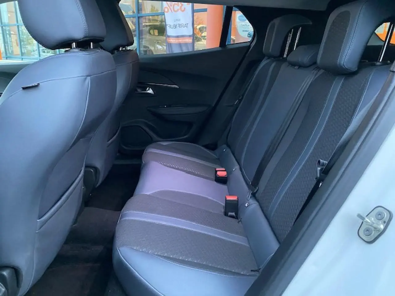 Vue intérieure côté droit sur la banquette arrière noire et grise du Peugeot 2008 blanc de 2020 avec appuie-têtes.